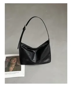 Detail shot of black genuine leather hobo shoulder bag, showing soft texture and metal buckle.