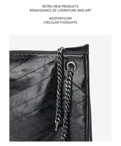 Détail de matelassage chevron en cuir noir froissé avec chaîne métallique et style élégant.