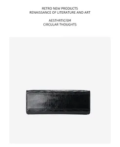 Sac cabas noir en cuir véritable avec design matelassé froissé et bandoulière en chaîne pour femme.