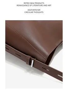 Close-up detail of premium brown cowhide leather shoulder bag texture and metal hardware.
