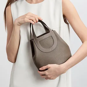 Togo leather bucket bag for women, stylish top handle handbag with classic pig nose design.