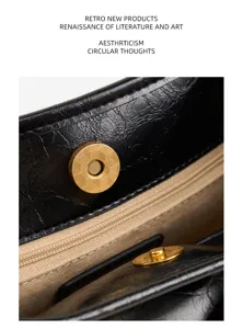 Black leather tote bag interior detail featuring gold magnetic snap closure and soft lining.