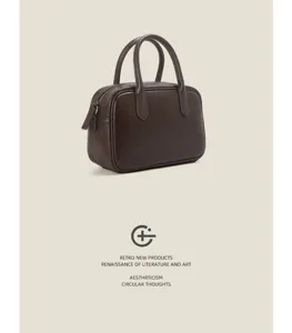 Close-up detail of the vintage brown leather Boston bag showing fine texture and smooth zipper.