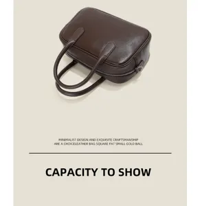 Dark brown leather boston bag detail showing premium texture and sturdy top handles