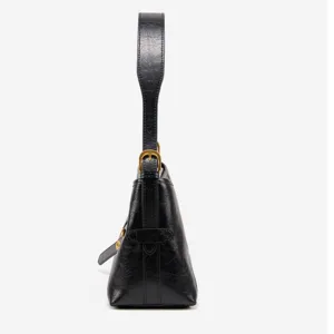 Side detail view of black leather shoulder bag with buckle, showing premium texture and profile.