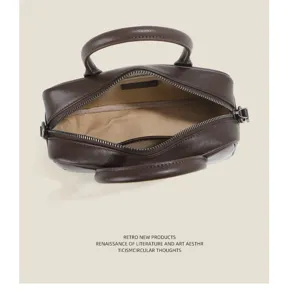 Detailed top view of genuine leather Boston bag interior zipper and double top handles.