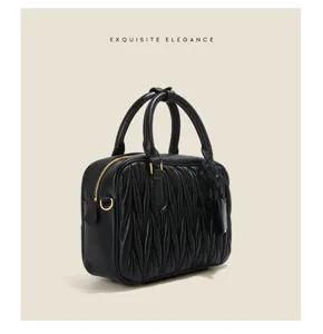 Black pleated leather bowling bag with gold hardware, elegant top handle boston handbag for women.