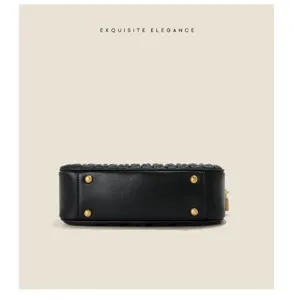 Detail view of black pleated leather bag bottom featuring four golden metal protective feet.