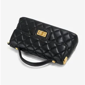 Black quilted leather handbag with gold turnlock, stylish top handle and crossbody design.