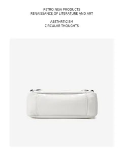 Close up detail of white leather motorcycle bag bottom with rivets and premium texture.