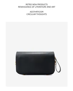 Detailed view of black cowhide leather handbag, highlighting fine texture and hardware.