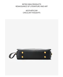 Detailed bottom view of black leather Boston bag featuring gold tone metal feet and side handle.
