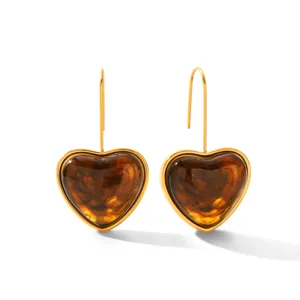 Gold-toned stainless steel heart earrings with amber tortoise resin detail, elegant accessory.