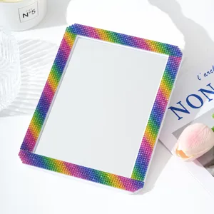 Rhinestone desktop makeup mirror close-up, colorful sparkling crystals frame detail view.