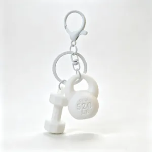 Mini gym equipment keychain detail, white dumbbell and kettlebell charms accessory.