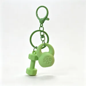 Mini fitness equipment keychain detail showing green dumbbell and kettlebell pendant design.
