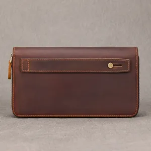 Close-up detail of dark brown genuine leather men's clutch wallet with sturdy wrist strap.