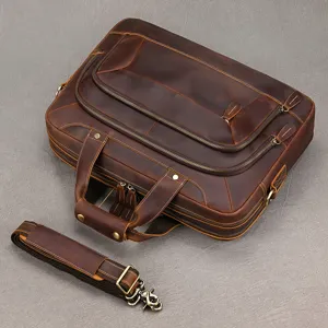 Dettaglio borsa ventiquattr ore in pelle vintage da uomo con scomparti multipli e accessori.