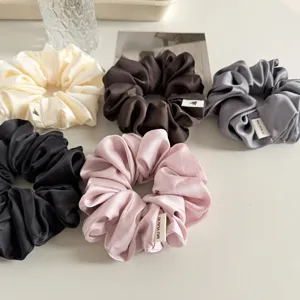 Detailansicht mehrfarbiger Satin Haargummis, glatte Textur, elegante Haaraccessoires für Alltag.