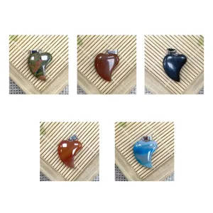 Close up of natural stone heart shaped gemstone pendants with metal bails for DIY jewelry making.