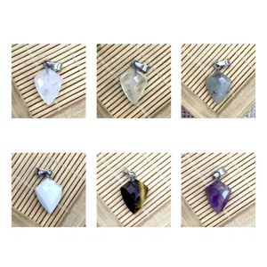 Détails en gros plan de divers pendentifs en pierre de cristal polygonaux avec attache.