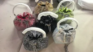 Detail shot of sparkling rhinestone bucket bags with chain straps in multiple vibrant colors.