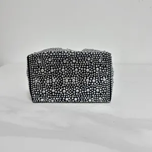 Detailed shot of a gorgeous black evening clutch bag fully covered with sparkling rhinestones.