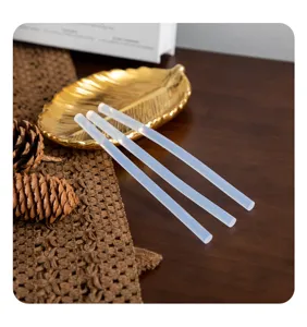 Detail shot of clear hot melt glue sticks displayed on a wooden table with autumn decor.