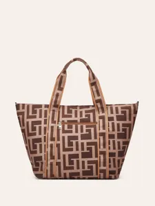 Gros plan sur le détail du sac cabas en toile imprimée géométrique rétro avec poche zippée.