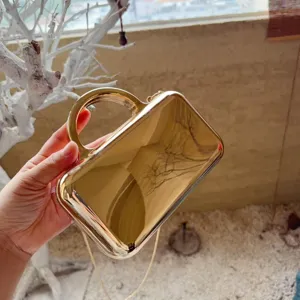 Gold mirror metallic clutch bag evening purse with top handle and chain strap detail view.