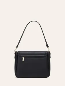 Detailed view of black faux leather shoulder bag with gold hardware and zipper pocket.