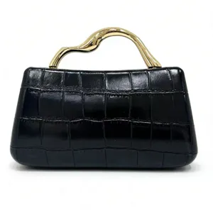 Bolso negro textura cocodrillo con elegante asa de metal dorada para cenas formales.