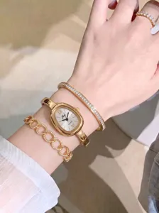 Nahaufnahme der eleganten französischen ovalen Quarzuhr mit edlem Schmuckset am Handgelenk.