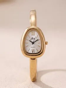 Detailaufnahme der goldenen Armbanduhr mit ovalem Zifferblatt und Quarzwerk, edles Design.