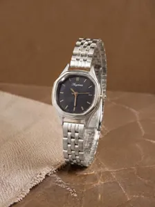 Close-up van het vintage achthoekige dames quartz horloge met donkere wijzerplaat en zilveren band.