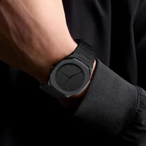 Close-up detail of luxury all-black quartz wristwatch with octagonal bezel on male wrist.