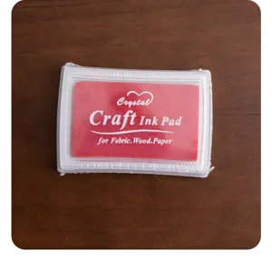 Red ink pad in plastic case with clear print for fabric wood and paper crafts detailing