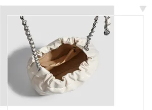 Detailed view of white gathered cloud bag interior with chain strap and zipper pocket texture.