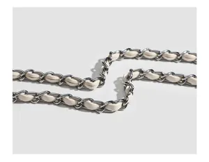 Detail shot of the stylish intertwined leather and metal chain strap for women bags.