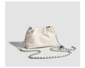 Detail shot of white gathered cloud crossbody bag with metallic chain strap and chic design.