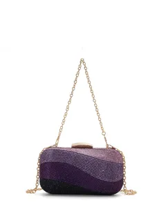 Close-up detail of luxury gradient purple rhinestone evening clutch bag with golden chain strap.