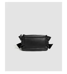 Schwarze Leder Umhängetasche Detail mit eleganter Schleife und stilvollem Plisséedesign.