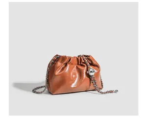 Brown crinkled leather cloud bag with chain strap and metal ball detail, detail view.