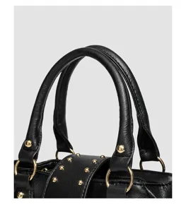 Schwarzes Leder Handtasche Detail Nahaufnahme zeigt Metallringe und dekorative Nieten.