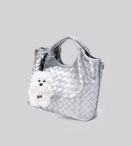Silberne geflochtene Handtasche mit Hundeschluesselanhaenger, stilvolle Umhaengetasche.