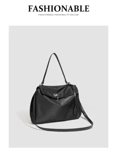 Close-up detail of the black nylon shoulder bag showing metal lock and durable strap design.