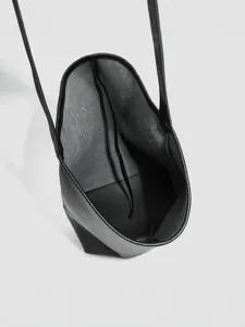 Bolso cubo negro de cuero suave minimalista bolso de hombro cruzado para mujer elegante.