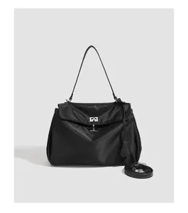 Black nylon shoulder handbag detail featuring silver turn-lock clasp and strap elements.
