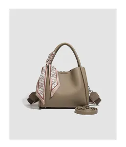Gedetailleerd overzicht van de handtas met stijlvolle bedrukte sjaal accessoire.