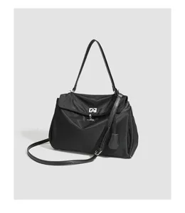 Detail view of black nylon commuter shoulder bag featuring silver metal lock clasp and strap.
